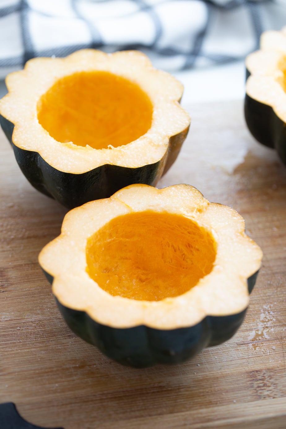 Raw acorn squash cut in half with the seeds removed.