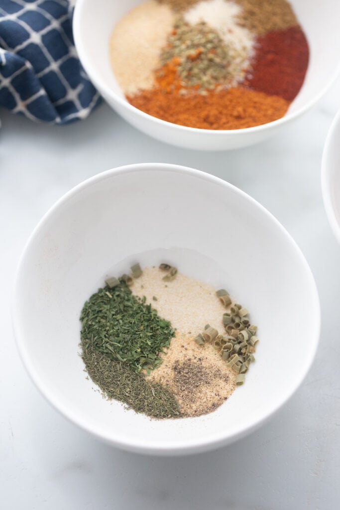 Overhead image: two white bowls of spices; homemade taco seasoning and homemade ranch seasoning