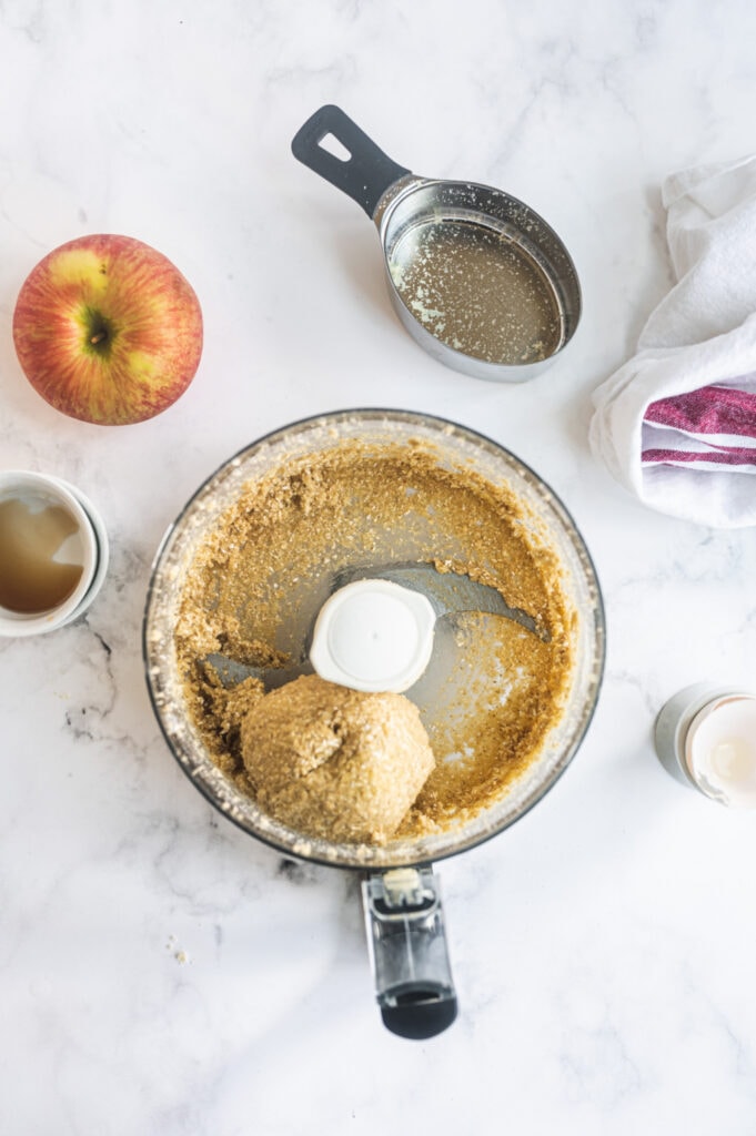 Overhead photo of a food processor with a ball of dough made primarily from almond flour and oat flour