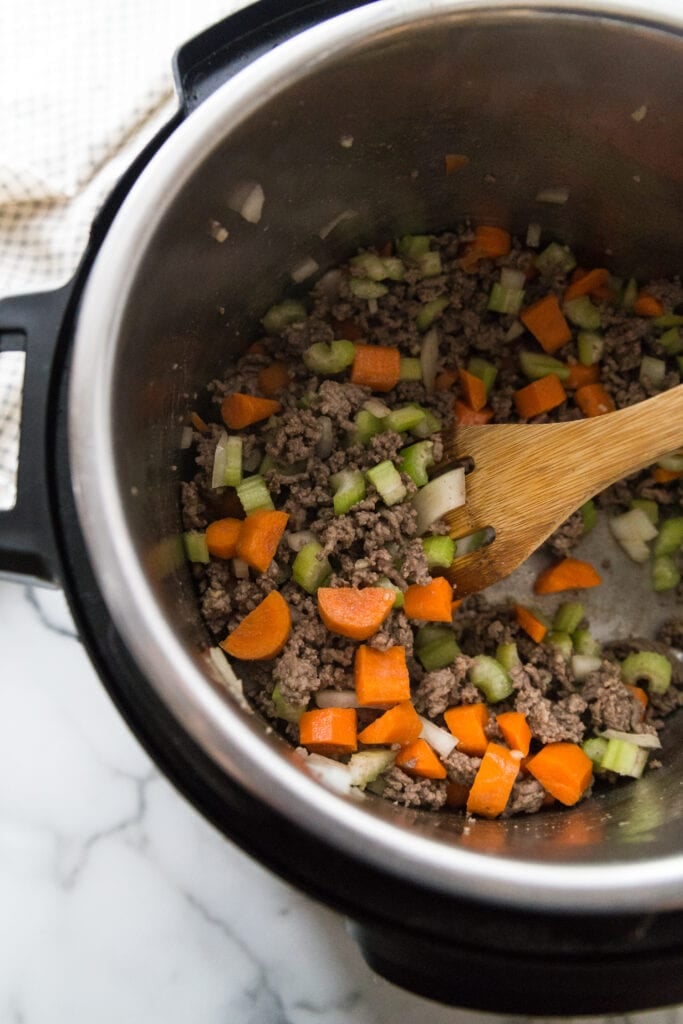 Step one of Instant Pot Cheeseburger soup is to saute the veggies and the ground beef 