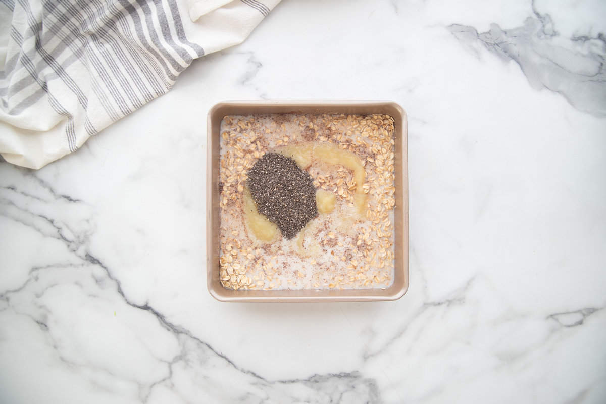 Ingredients for one pan baked oats mixed directly into a square baking dish.