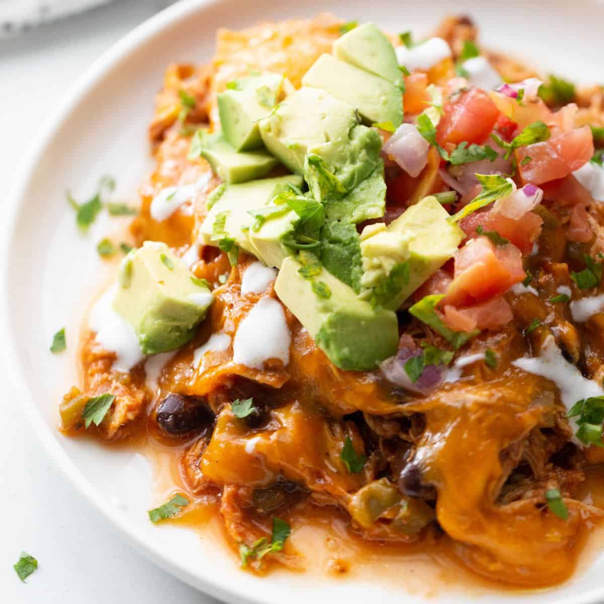 Plate of crock pot chicken enchilada casserole made in the crock pot.