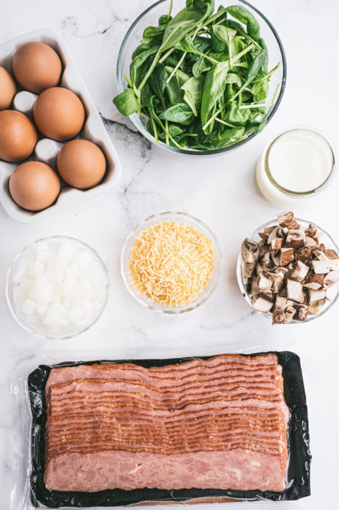 The ingredients for breakfast bites are spread out on a white surface.