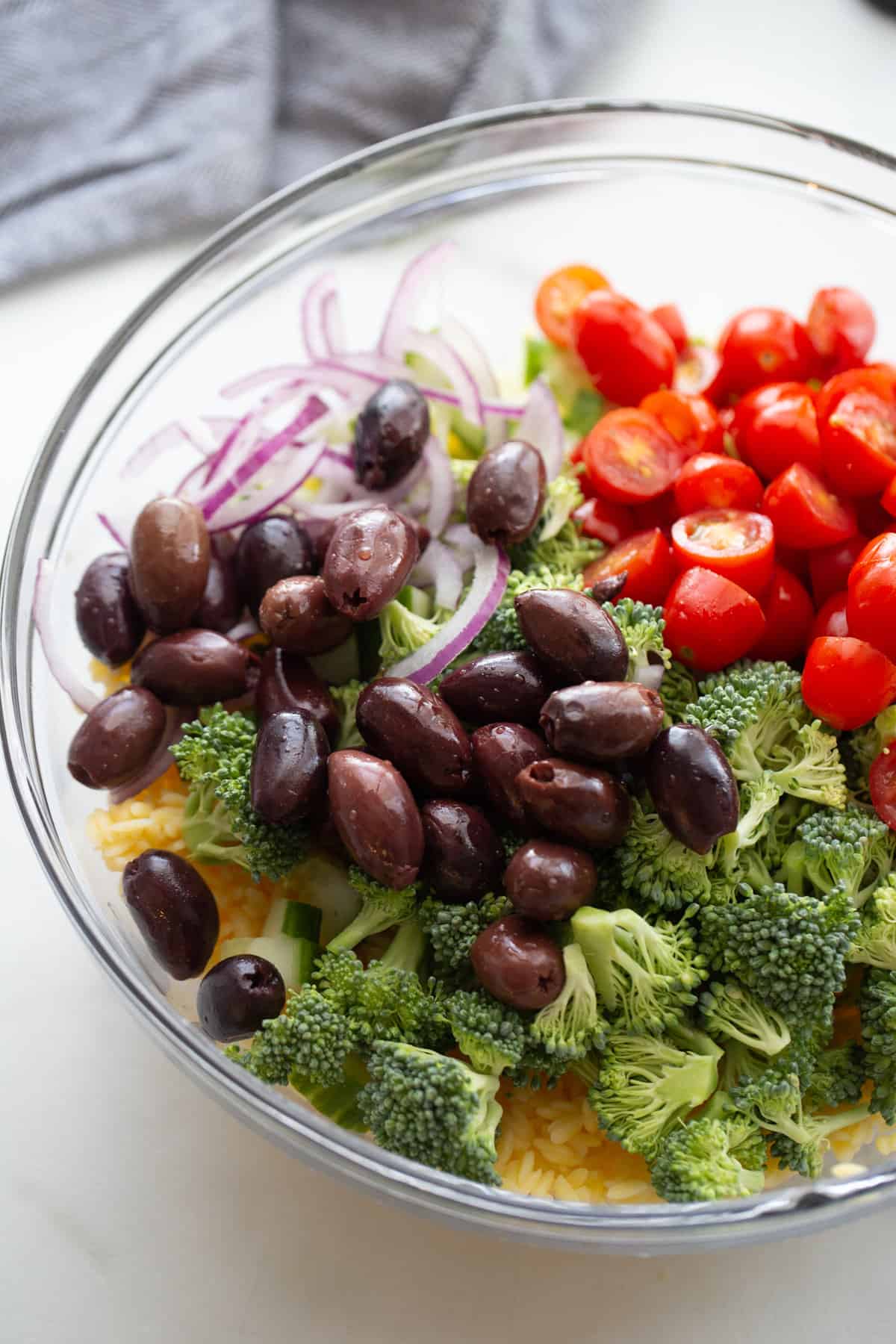 Ingredients for Gluten Free Orzo Salad in a glass bowl