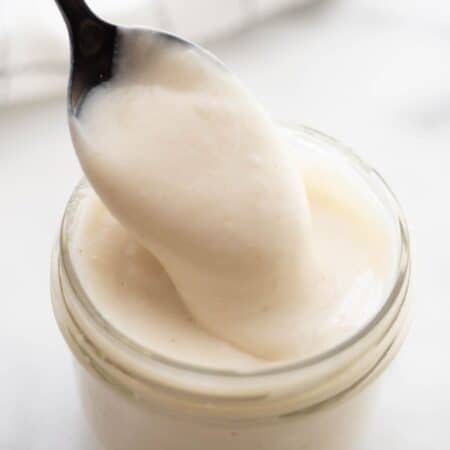 Spoon dipping into a mason jar of healthier cream of chicken soup.