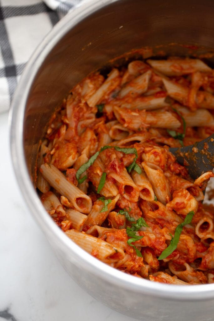 Overhead photo of an Instant Pot liner filled with gooey cheesy chicken parmesan pasta.