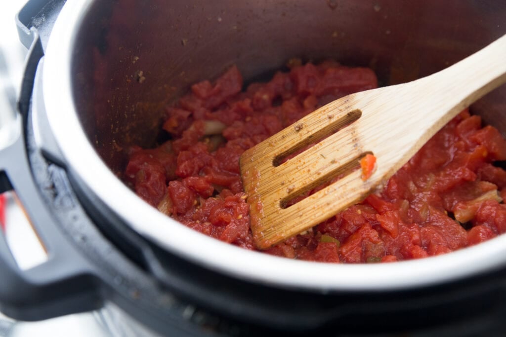 Tomatoes and sauce laying over pasta in an Instant Pot