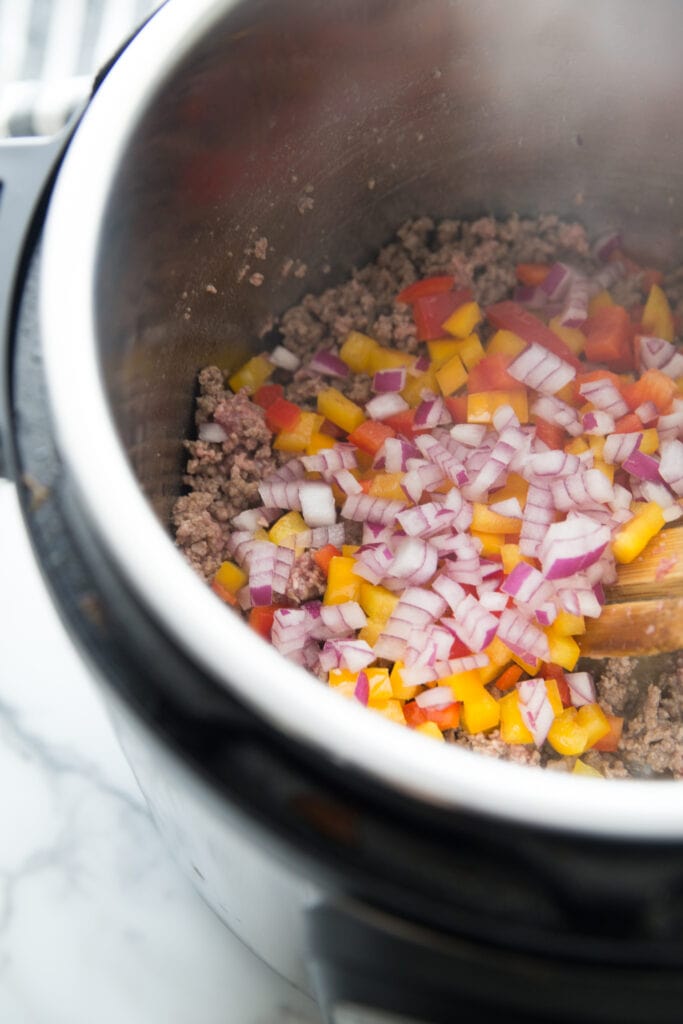 A prep shot of Instant Pot Beef Enchiladas - the veggies are being sauteed with the ground beef. 