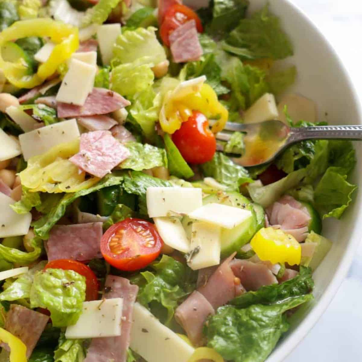 Bowl with an Italian Chopped Salad on a white marble countertop.