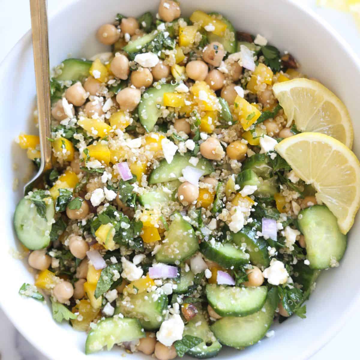 Bowl of the viral Jennifer Aniston Salad with chickpeas, quinoa, fresh veggies, and a lemon vinaigrette.