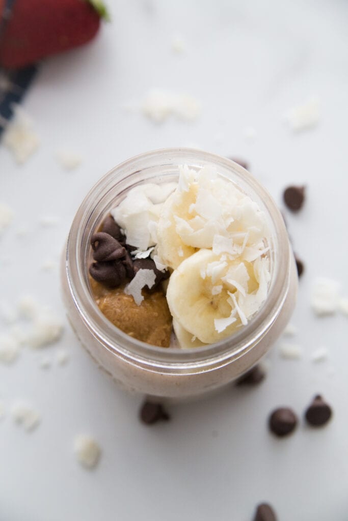 Chunky Monkey Overnight Oats on a marble counter top with chocolate chips scattered around 