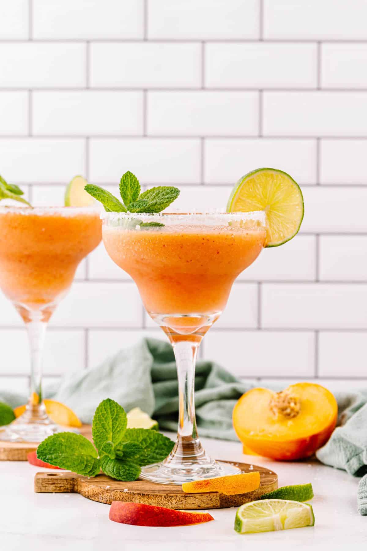 Two glasses of homemade peach margaritas.