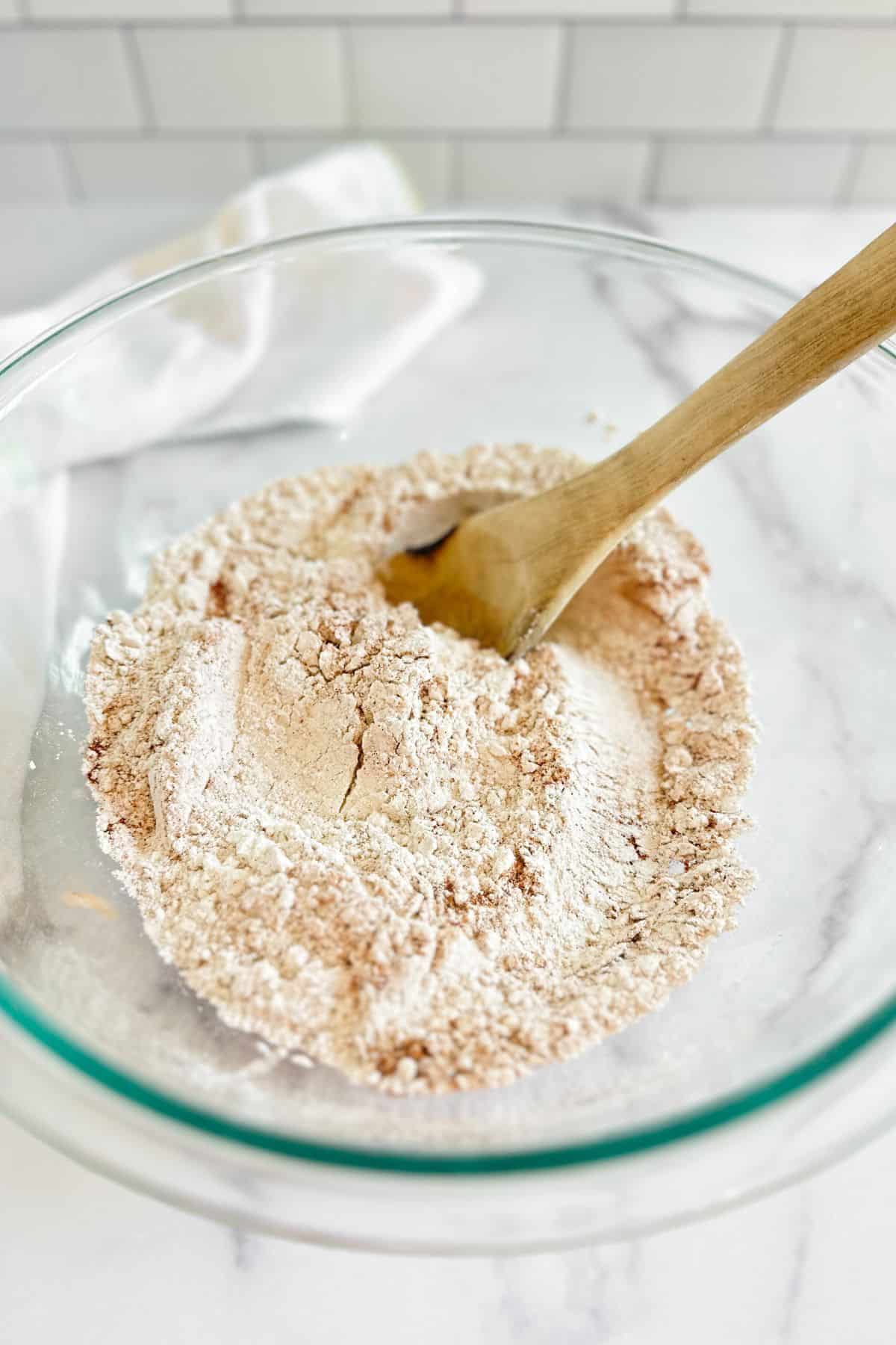 Dry ingredients for pumpkin muffins in a glass bowl.