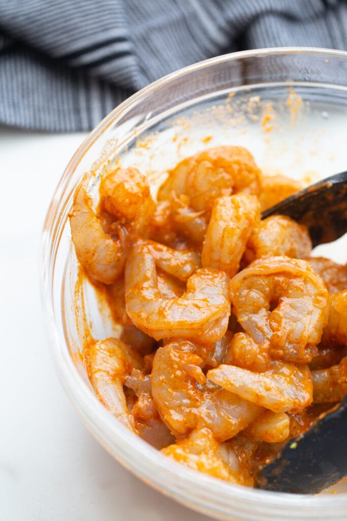 A bowl of shrimp with homemade taco seasoning and oil for air fryer shrimp