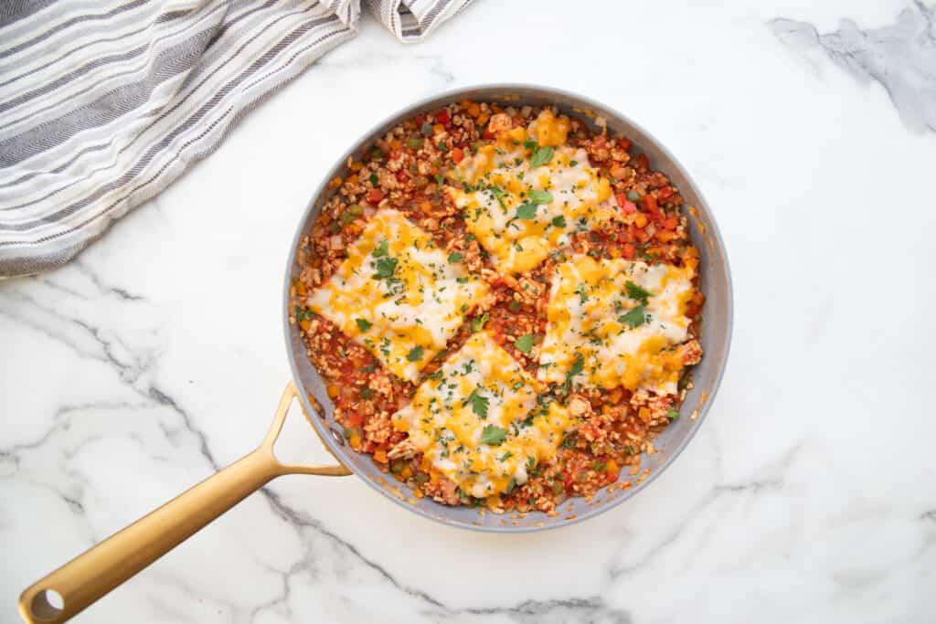 Stuffed Pepper skillet topped with three pieces of Monterey Jack Cheese.