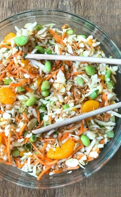 Ramen Noodle Salad in a Glass Bowl with Wooden tongs