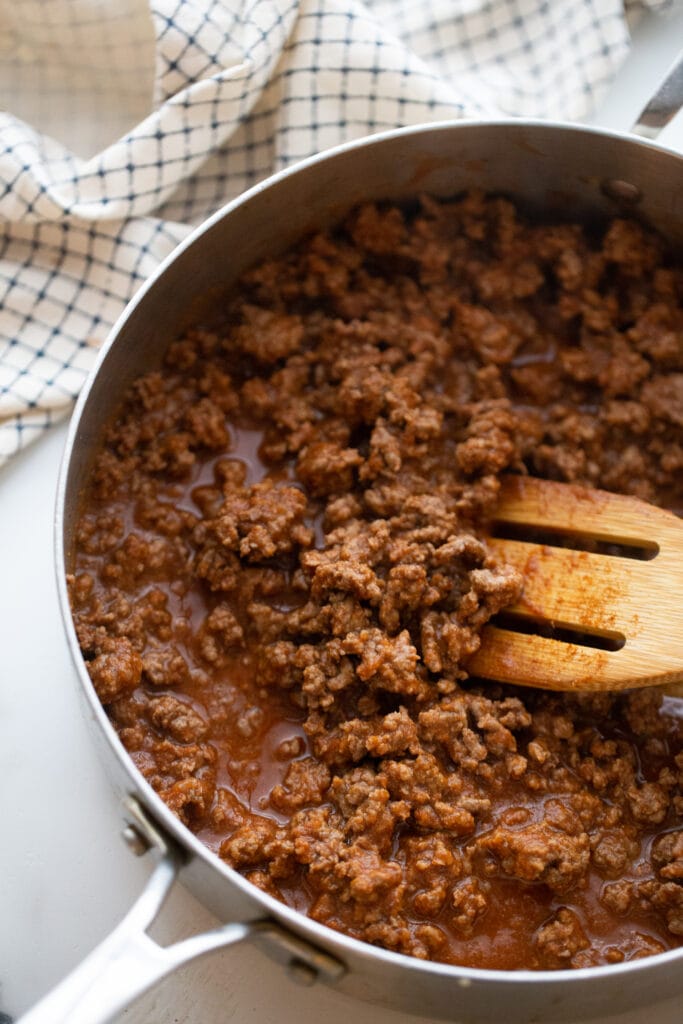 Pan of ground beef seasoned with taco seasoning and tomato sauce, ready for zucchini taco boats